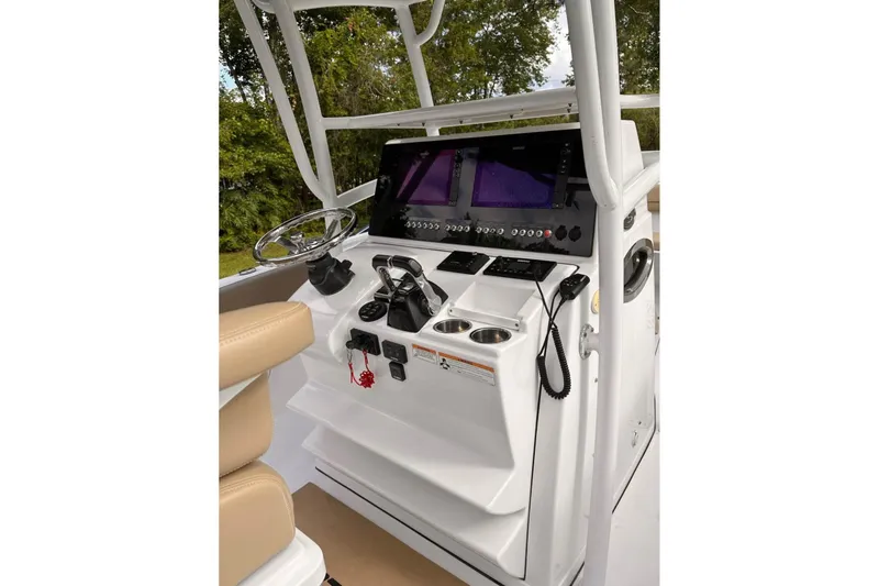 Slide: The Image of 2018 Sportsman Open 252 Center Console boat dashboard with steering wheel and navigation screens. - 3