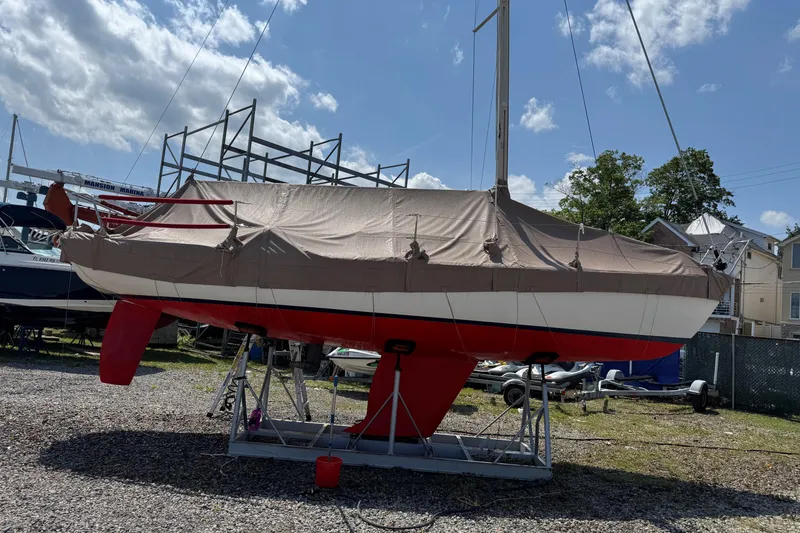Slide: The Image of 2006 Alerion Express 28 sailboat covered and docked at a marina under a blue sky. - 3