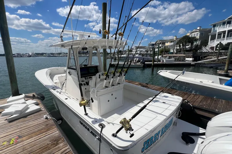 Slide: The Image of 2025 Regulator 28 fishing boat docked, equipped with multiple fishing rods under a sunny sky. - 12