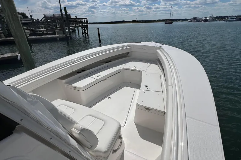 Slide: The Image of 2025 Regulator 28 boat with spacious seating, docked by the water under a cloudy sky. - 5