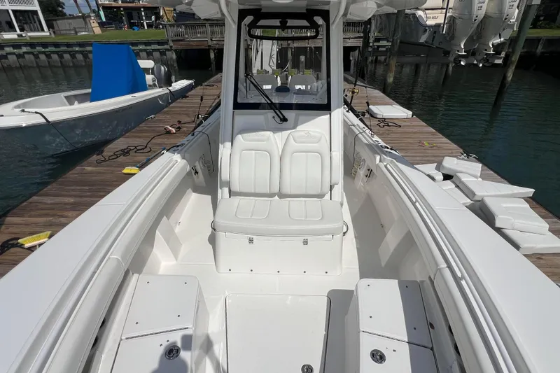 Slide: The Image of 2025 Regulator 28 boat interior, featuring white seating and sleek design at a dock. - 6
