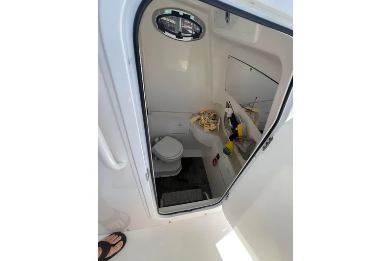 Slide: The Image of 2025 Regulator 28 boat interior with compact bathroom and storage shelves. - 9