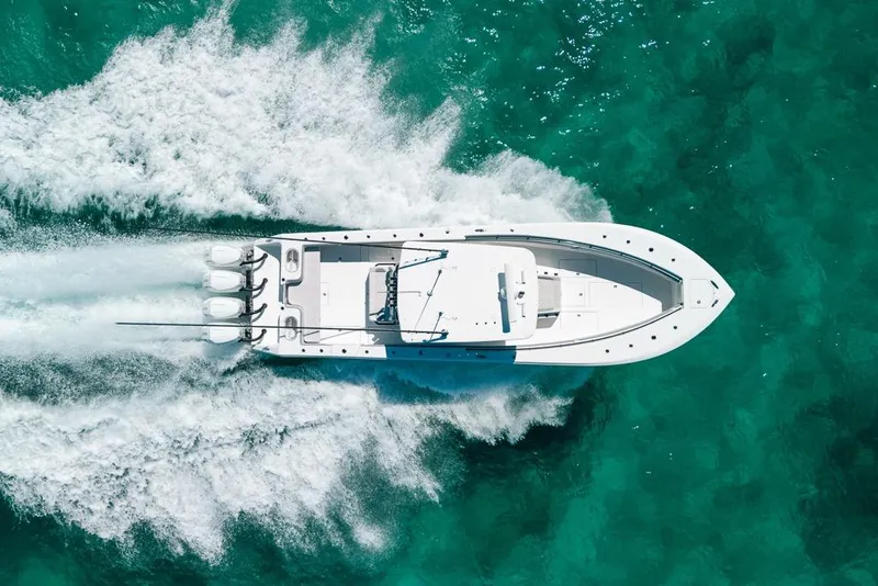 Slide: The Image of 2024 SeaHunter 39 Tournament boat cruising on turquoise water, aerial view. - 12