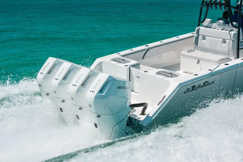 Slide: The Image of 2024 SeaHunter 39 Tournament boat with powerful Mercury outboard engines cruising on turquoise water. - 14