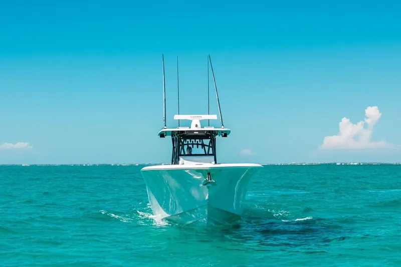 Slide: The Image of 2024 SeaHunter 39 Tournament boat cruising on clear turquoise waters under a bright blue sky. - 4