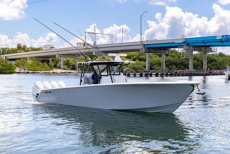 Slide: The Image of 2024 SeaHunter 39 Tournament boat cruising under a bridge on a sunny day. - 44
