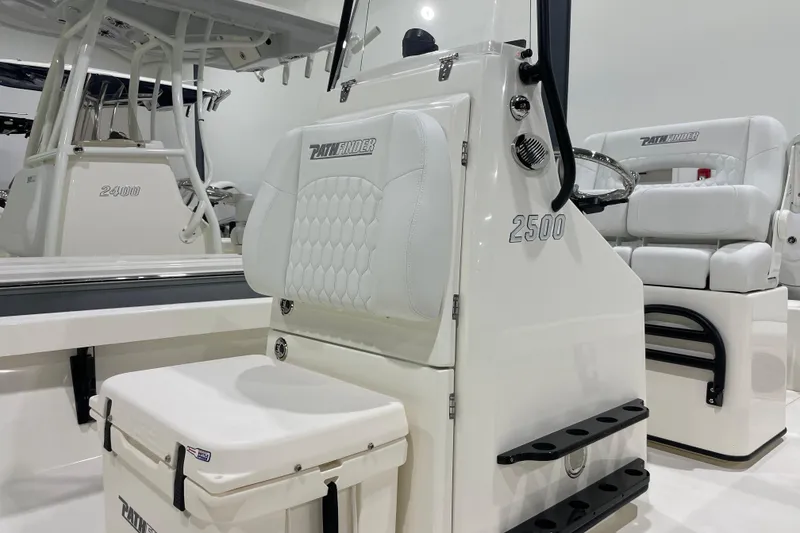 Slide: The Image of 2026 Pathfinder 2500 Hybrid boat interior with white seating and steering console. - 1
