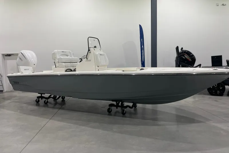 Slide: The Image of 2026 Pathfinder 2500 Hybrid boat displayed indoors on wheeled stands. - 11