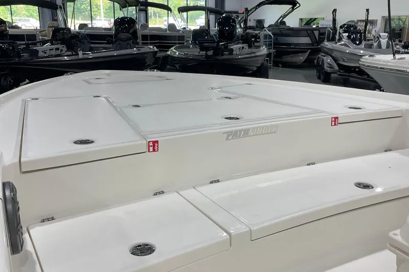 Slide: The Image of 2026 Pathfinder 2500 Hybrid boat deck in showroom, surrounded by other boats. - 5