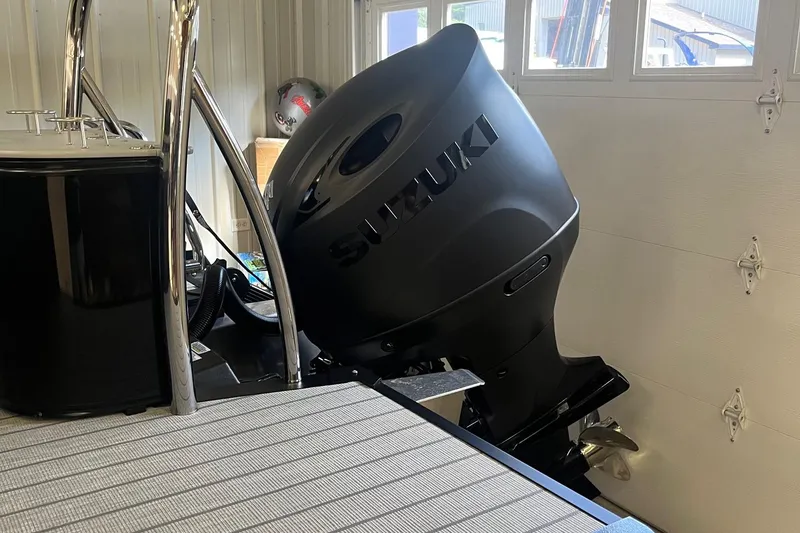 Slide: The Image of 2026 Avalon 25 LSZ Versatile Rear Lounger with Suzuki outboard motor in garage. - 6