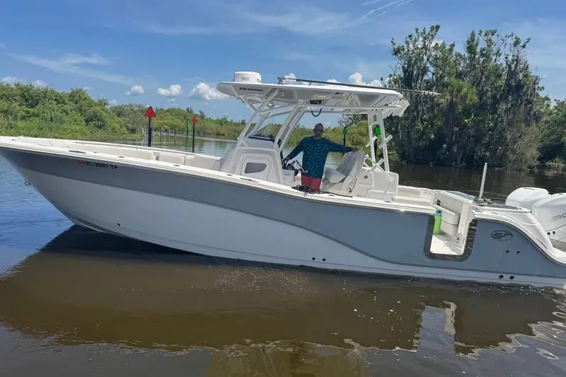 Slide: The Image of 2023 Sea Fox 328 Commander boat on calm water, surrounded by lush greenery. - 14