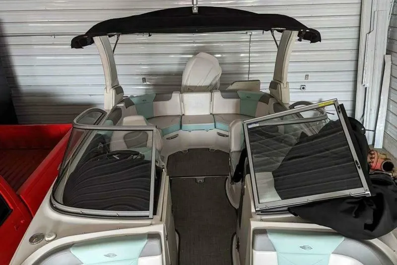 Slide: The Image of 2021 Chaparral 230 Suncoast boat interior with seating and canopy in storage. - 14