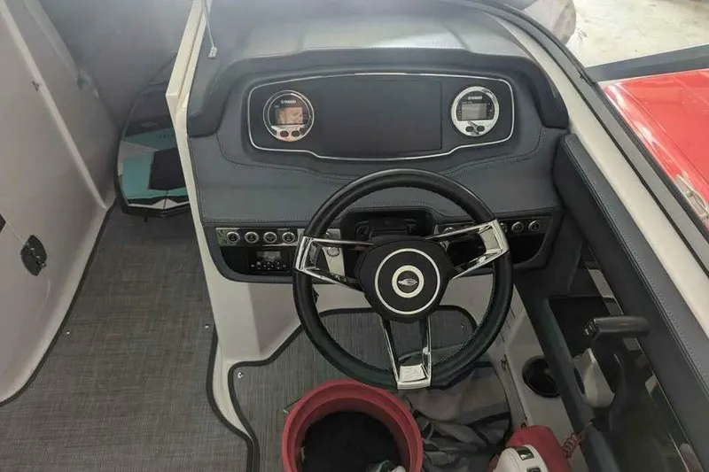 Slide: The Image of 2021 Chaparral 230 Suncoast boat dashboard with steering wheel and controls. - 15
