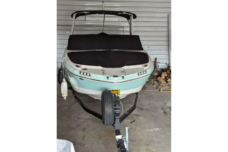 Slide: The Image of 2021 Chaparral 230 Suncoast boat on trailer in garage setting. - 2