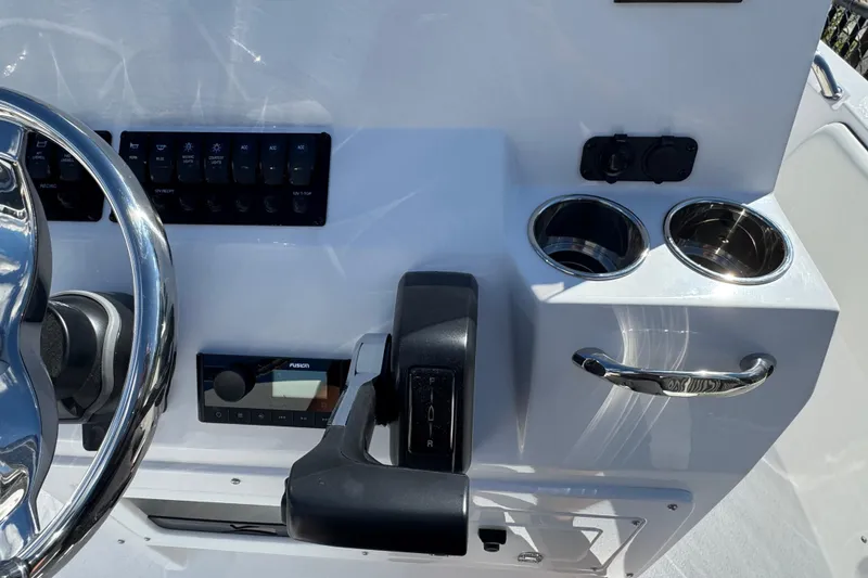 Slide: The Image of 2026 Stingray 173 CC boat console with steering wheel, controls, and cup holders. - 11