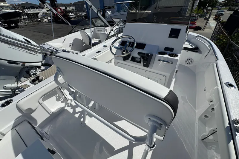 Slide: The Image of 2026 Stingray 173 CC boat interior with steering wheel and seating, docked outdoors. - 6
