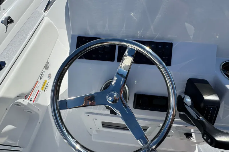 Slide: The Image of 2026 Stingray 173 CC boat steering wheel and control panel close-up. - 8