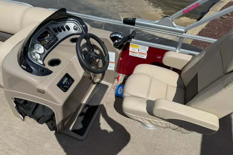 Slide: The Image of 2023 Sun Tracker Party Barge 20 DLX helm with beige captain's chair and control panel. - 11