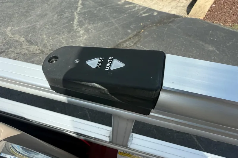 Slide: The Image of 2023 Sun Tracker Party Barge 20 DLX control panel with raise and lower buttons. - 14