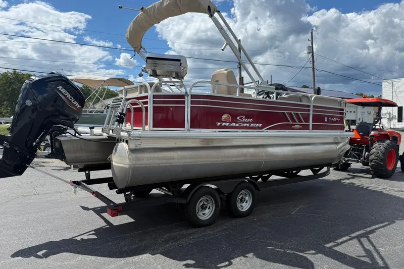 Slide: The Image of 2023 Sun Tracker Party Barge 20 DLX pontoon boat on trailer, parked outdoors. - 5