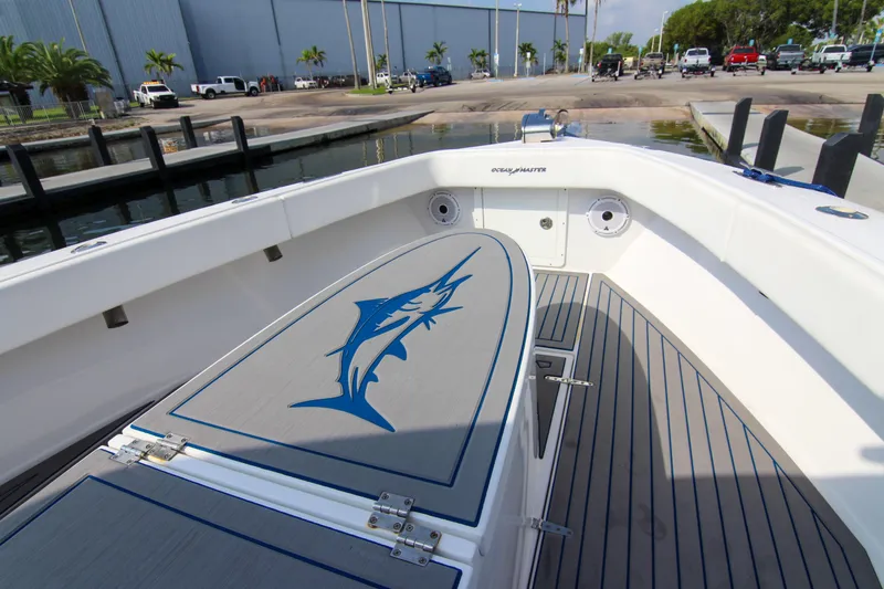 Slide: The Image of 1996 Ocean Master 31 Center Console boat with marlin design, docked at marina. - 23