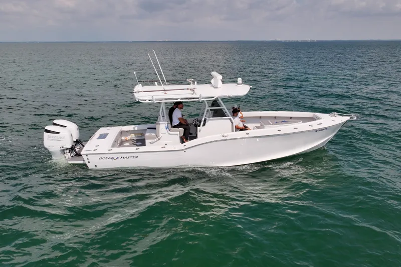 Slide: The Image of 1996 Ocean Master 31 Center Console boat cruising on open water. - 32