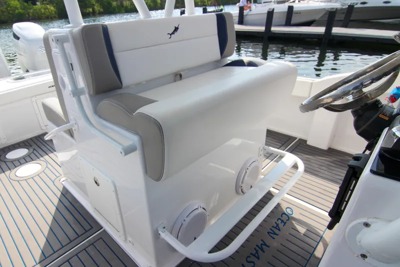 Slide: The Image of 1996 Ocean Master 31 Center Console boat interior with cushioned seating and steering wheel. - 6