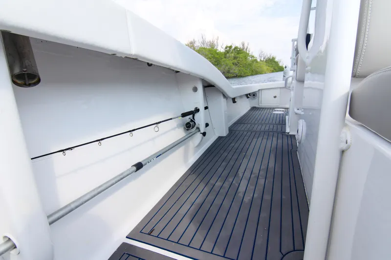 Slide: The Image of 1996 Ocean Master 31 Center Console boat interior with rod holders and sleek flooring. - 7