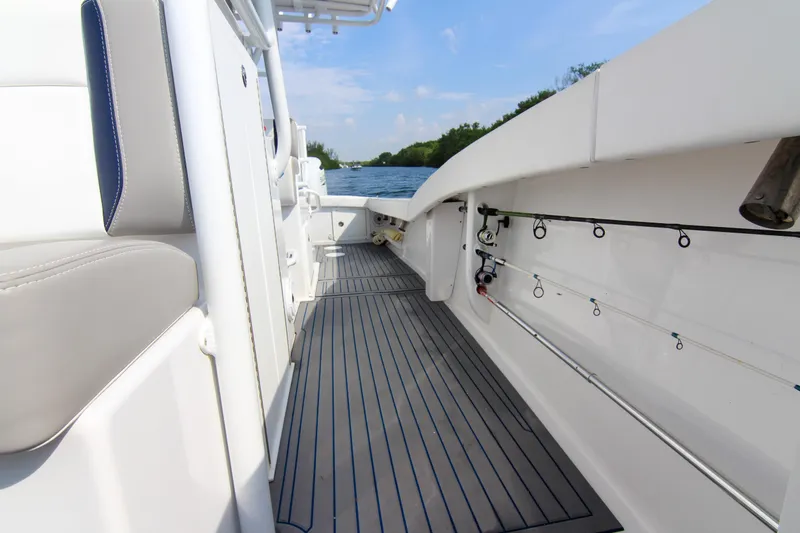 Slide: The Image of 1996 Ocean Master 31 Center Console boat interior with fishing rods and seating. - 8