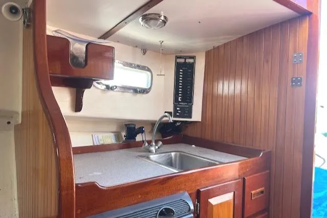 Slide: The Image of Interior of 2001 Duffy 26 boat featuring a compact wooden kitchenette with sink. - 11