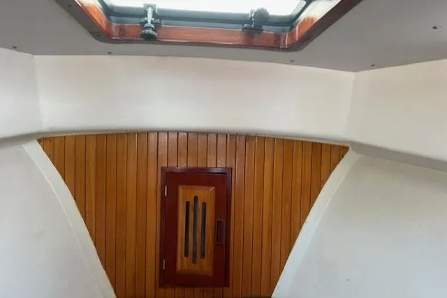 Slide: The Image of Interior of a 2001 Duffy 26 boat, featuring wood paneling and a skylight. - 19