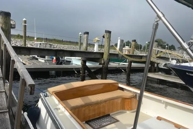 Slide: The Image of Boat docked at marina, Duffy 26 model, 2001, with wooden seating and overcast sky. - 2