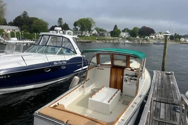 Slide: The Image of 2001 Duffy 26 boat docked beside another vessel in a scenic marina. - 3