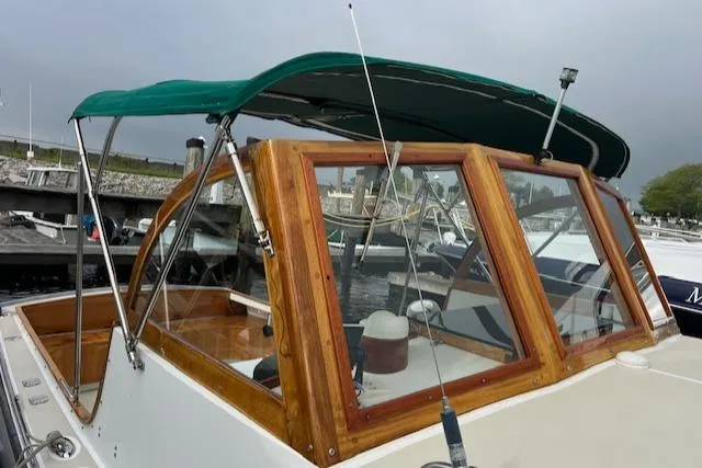 Slide: The Image of 2001 Duffy 26 boat with green canopy and wooden frame at marina. - 4
