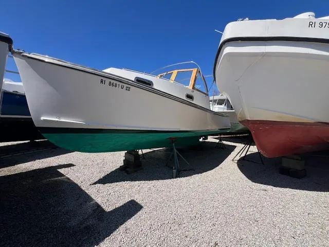 Slide: The Image of 2001 Duffy 26 boat on stands, white hull, green bottom, clear sky background. - 9