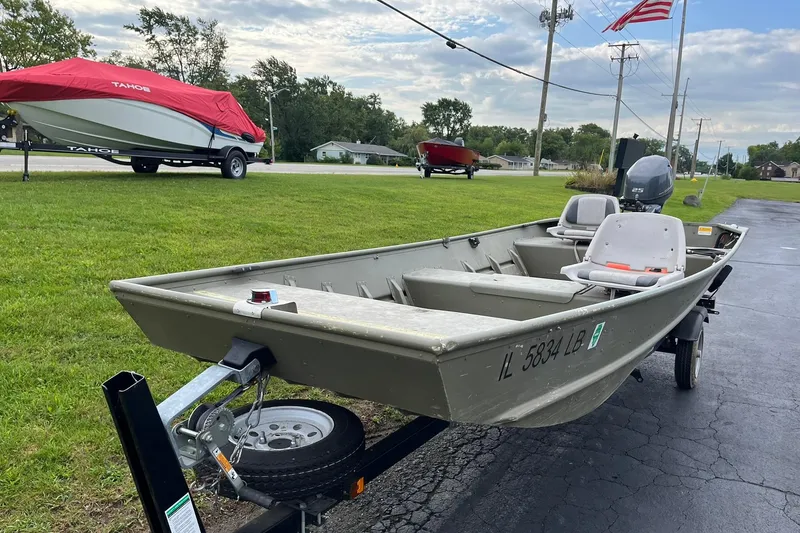 Slide: The Image of 2008 Crestliner CR 1648 boat on trailer, parked on driveway with grass and flag in background. - 6