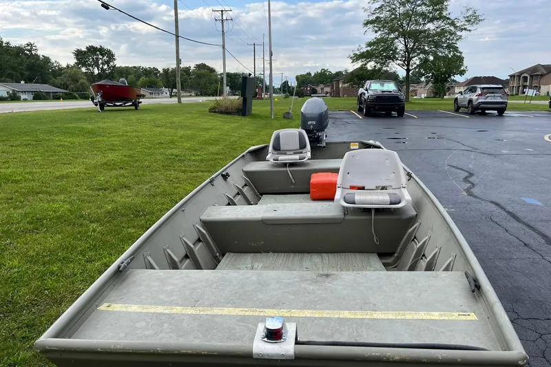 Slide: The Image of 2008 Crestliner CR 1648 boat parked on grass near road and vehicles. - 7