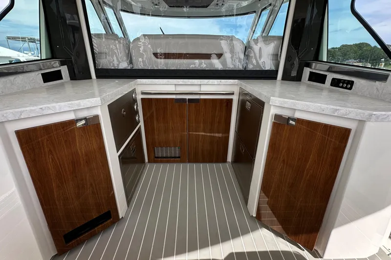 Slide: The Image of Interior of 2026 Tiara Yachts 48 LS, featuring sleek wood cabinetry and modern countertops. - 13