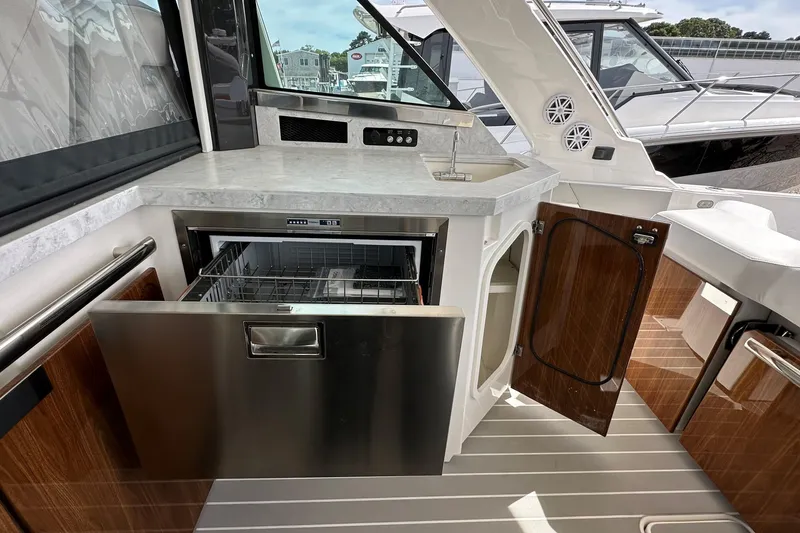 Slide: The Image of 2026 Tiara Yachts 48 LS interior with modern kitchenette and stainless steel appliances. - 14