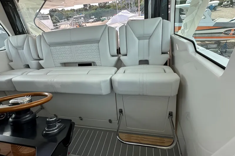 Slide: The Image of 2026 Tiara Yachts 48 LS interior with luxurious white seating and wooden steering wheel. - 22