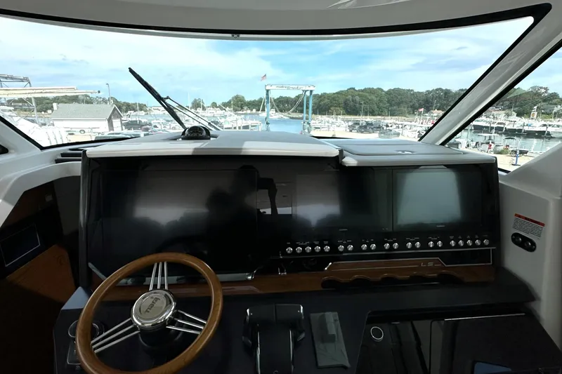 Slide: The Image of 2026 Tiara Yachts 48 LS helm with modern controls and panoramic marina view. - 23