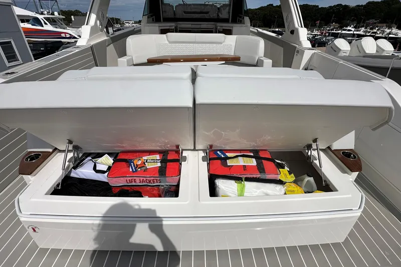 Slide: The Image of Open storage compartment on 2026 Tiara Yachts 48 LS, revealing life jackets and safety gear. - 3