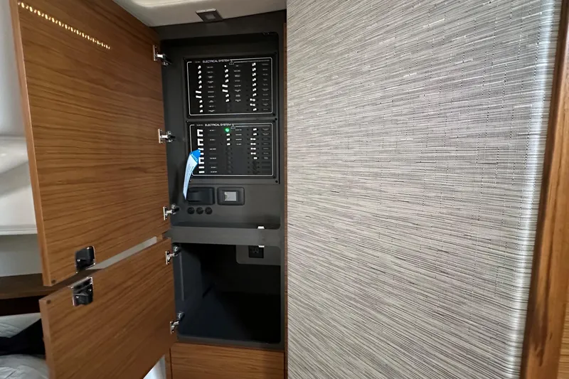 Slide: The Image of Electrical panel inside 2026 Tiara Yachts 48 LS, featuring wooden cabinetry and modern design. - 33
