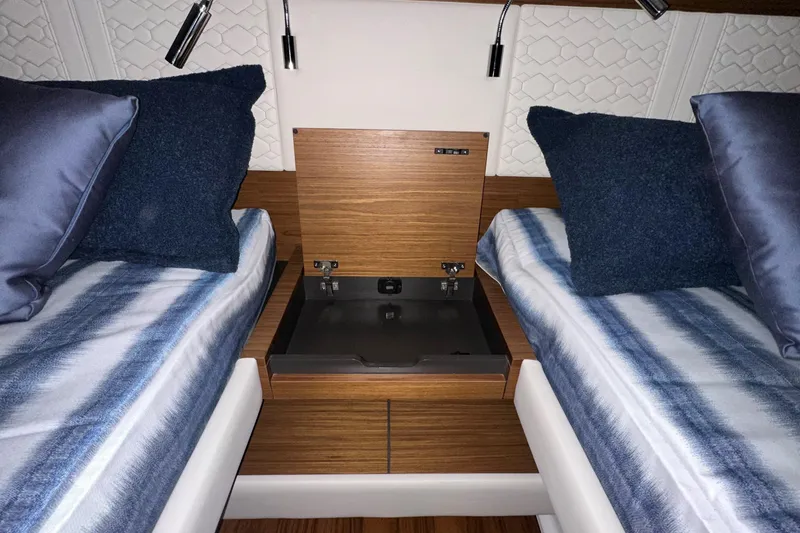 Slide: The Image of Interior of 2026 Tiara Yachts 48 LS with twin beds and wooden storage compartment. - 44