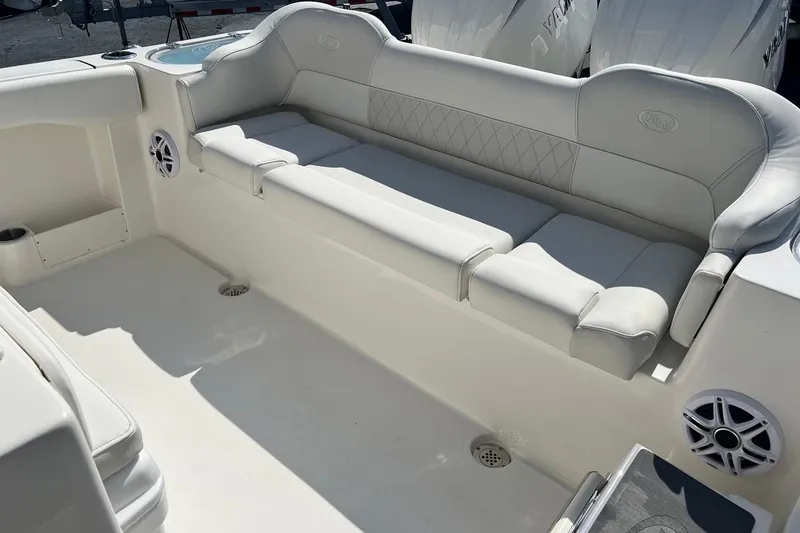 Slide: The Image of 2026 Key West 263 FS boat interior with white cushioned seating and built-in speakers. - 16