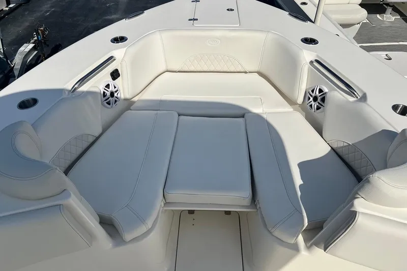 Slide: The Image of 2026 Key West 263 FS boat interior with white cushioned seating and speakers. - 24