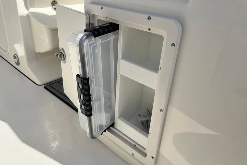 Slide: The Image of Storage compartment on 2026 Key West 263 FS boat, featuring organized shelves and secure latch. - 53