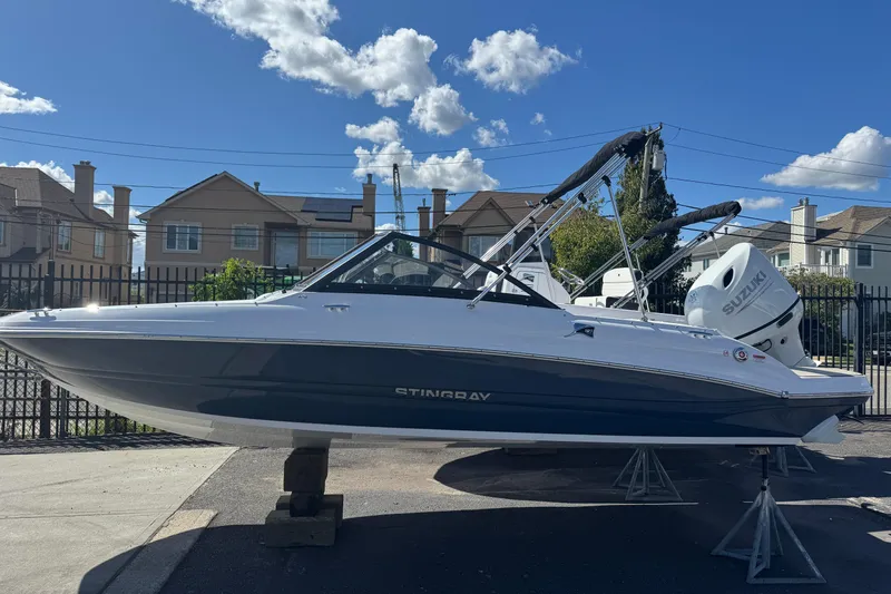 The Image of 2026 Stingray 191 DC boat displayed outdoors under a clear blue sky. - 1
