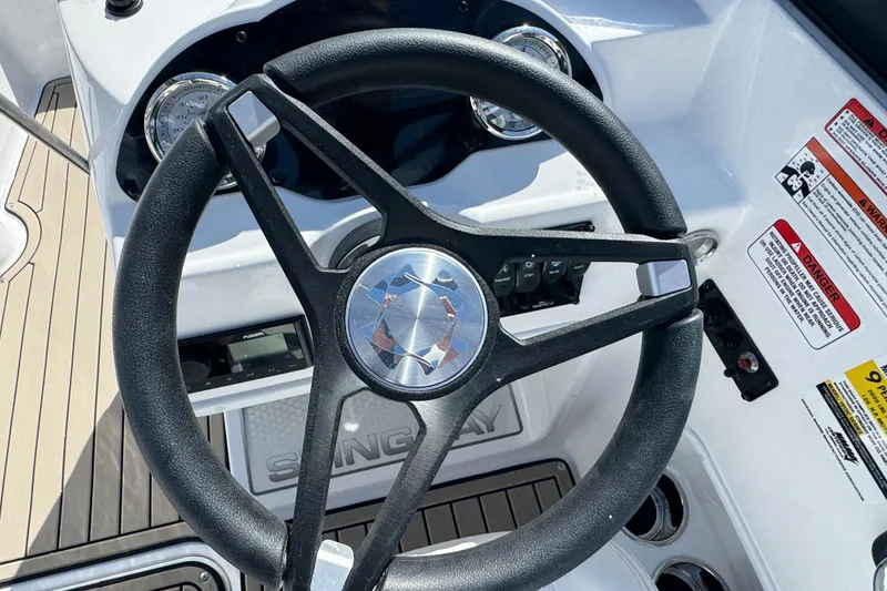 Slide: The Image of Steering wheel of 2026 Stingray 191 DC boat with dashboard controls and warning labels. - 11