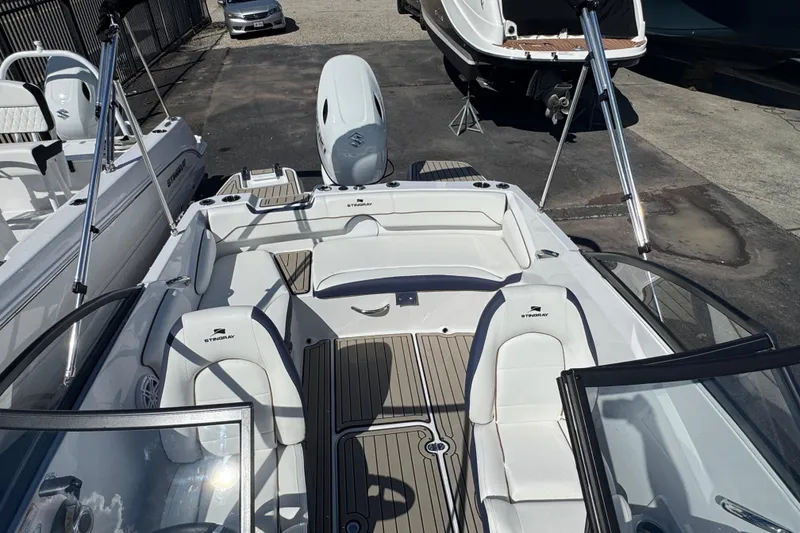 Slide: The Image of 2026 Stingray 191 DC boat interior with white seating and wood accents. - 20